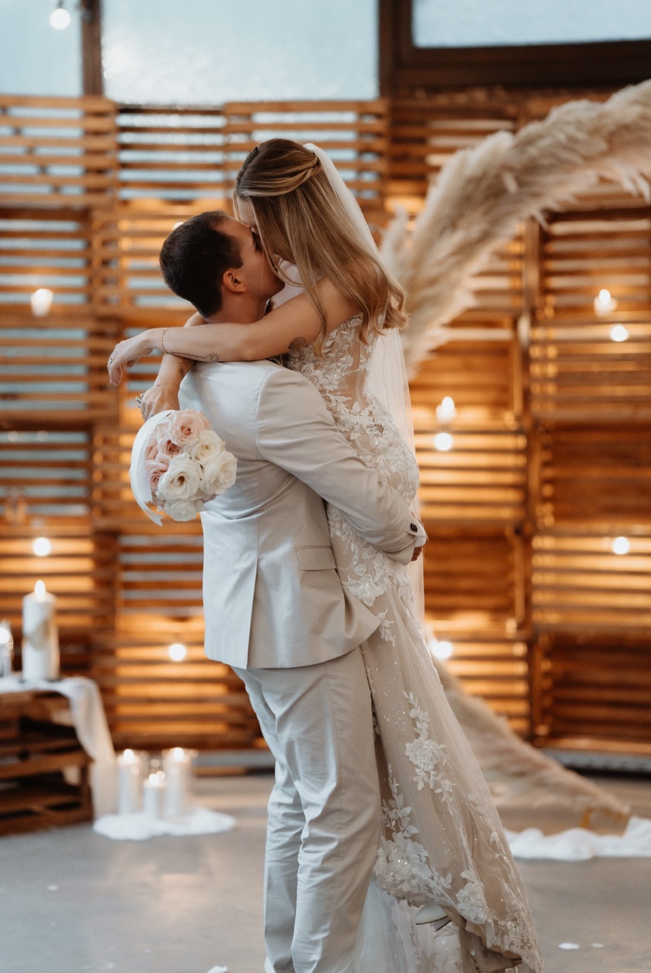 Ein Brautpaar küsst sich romantisch in einem schönen, sonnigen Hochzeitsumfeld.